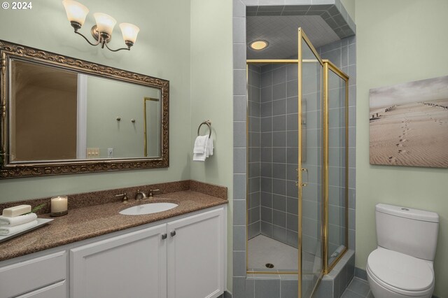 bathroom with a shower with shower door, vanity, and toilet