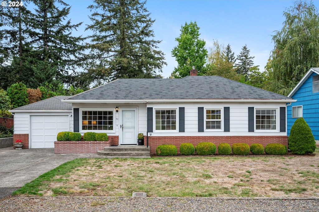 ranch-style home with a garage and a front lawn