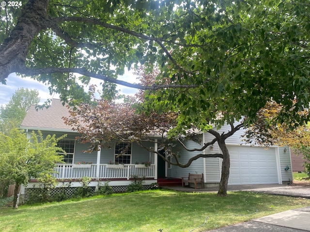 view of property hidden behind natural elements featuring covered porch and a front yard