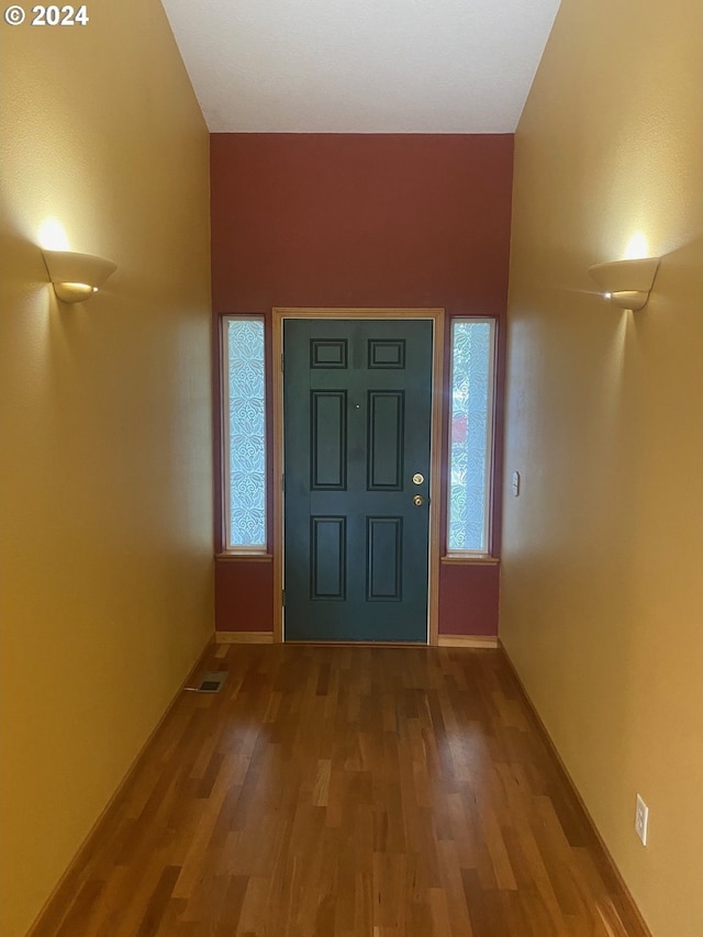foyer featuring baseboards, a wealth of natural light, wood finished floors, and visible vents