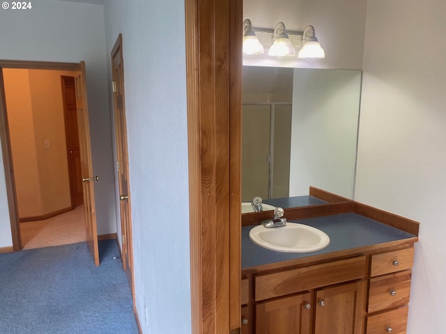 bathroom with a shower with door and vanity