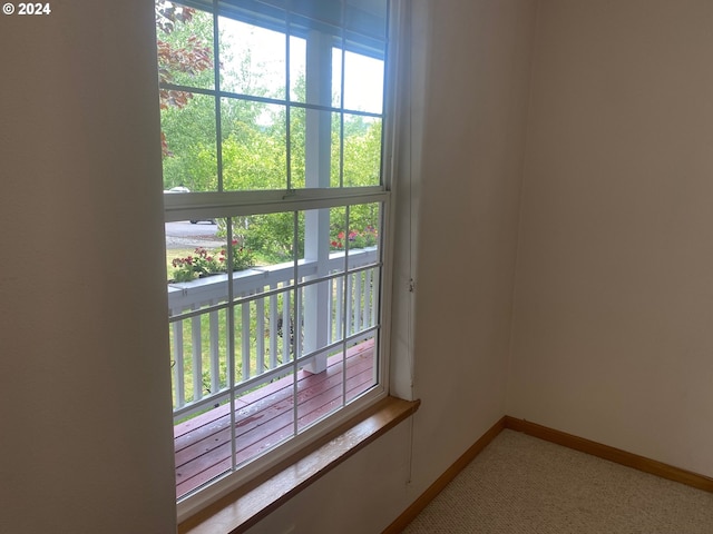 entryway featuring baseboards and light carpet