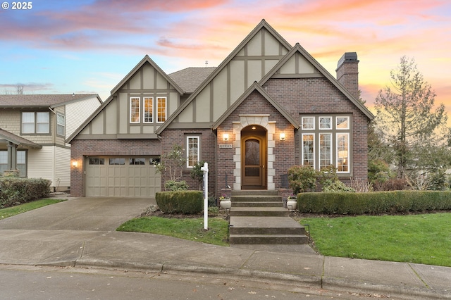 tudor home featuring a lawn and a garage