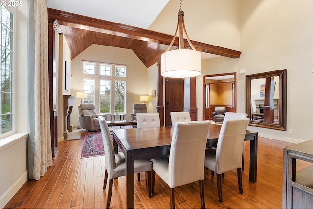 dining area featuring high vaulted ceiling and wood-type flooring