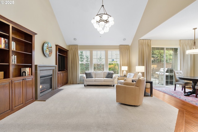 living room with wood-type flooring, high vaulted ceiling, and an inviting chandelier