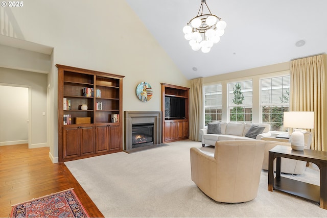 living room with a high ceiling, an inviting chandelier, and wood-type flooring