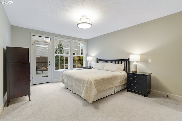 bedroom with a textured ceiling and light carpet