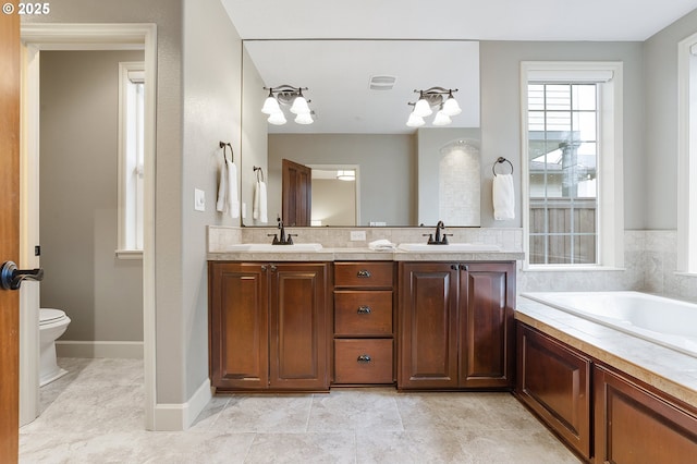 bathroom featuring a tub, vanity, and toilet