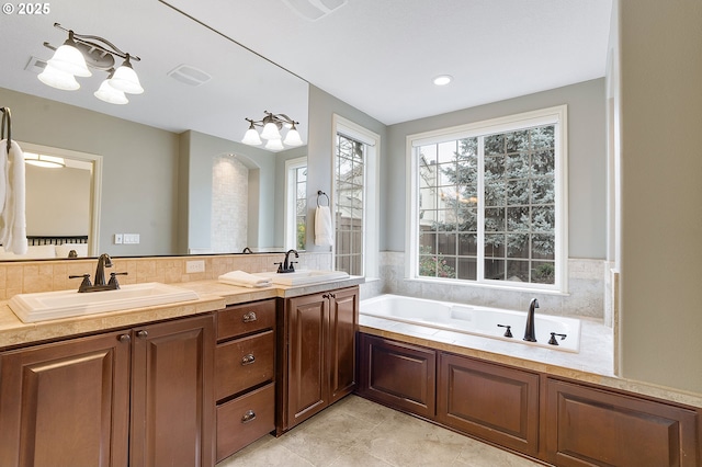 bathroom featuring vanity, decorative backsplash, and a tub to relax in