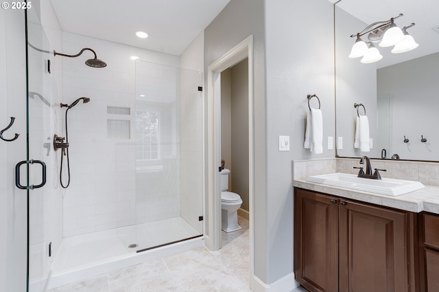 bathroom with a shower with door, vanity, and toilet