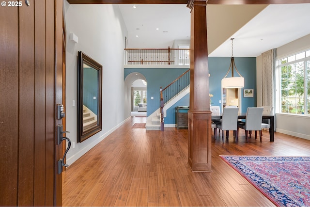 foyer entrance featuring a towering ceiling and hardwood / wood-style floors