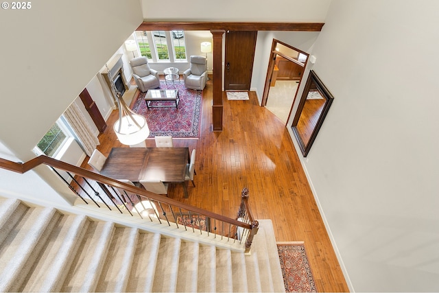 living room featuring a high ceiling, decorative columns, and wood-type flooring