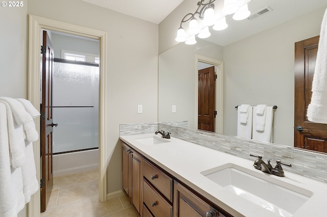 bathroom featuring shower / bath combination with glass door, backsplash, tile patterned floors, and vanity