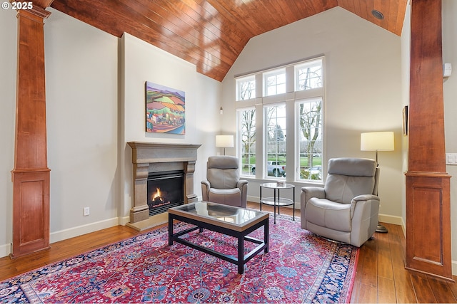 sitting room with high vaulted ceiling, hardwood / wood-style floors, wood ceiling, and decorative columns