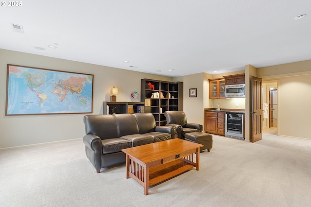 living room with wet bar, wine cooler, and light colored carpet