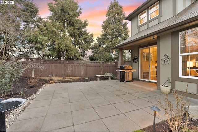 patio terrace at dusk featuring grilling area