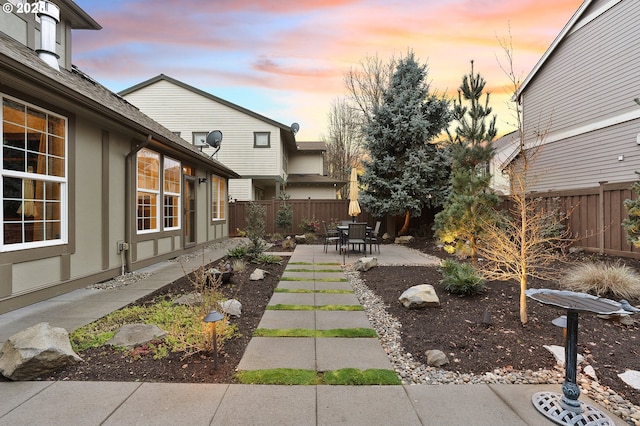 yard at dusk featuring a patio area