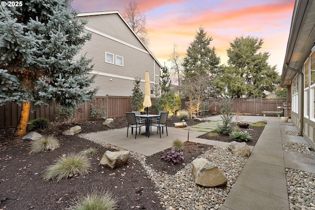 yard at dusk featuring a patio