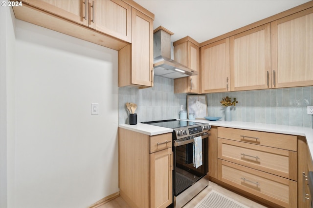 kitchen with backsplash, wall chimney range hood, light brown cabinets, and electric range