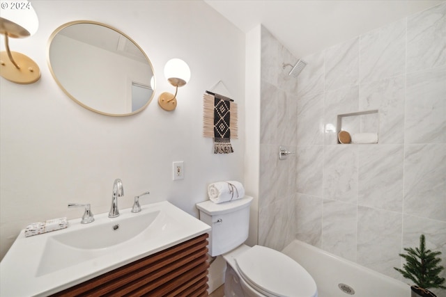 bathroom with vanity, toilet, and a tile shower