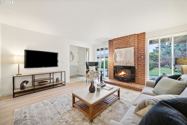 living room with a fireplace and light wood-type flooring