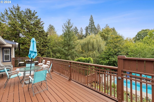 wooden terrace featuring outdoor dining area and a pool