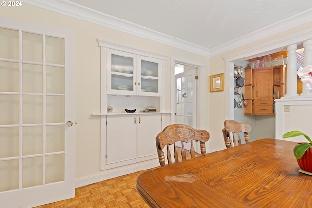 dining area with a textured ceiling, light parquet flooring, and ornamental molding