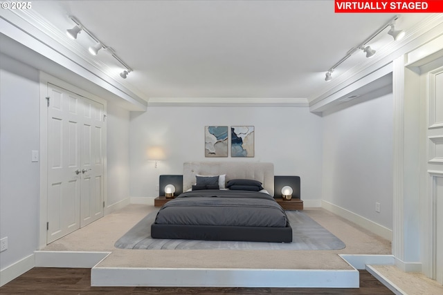 bedroom featuring baseboards and track lighting