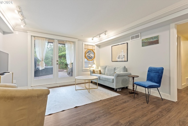 living room featuring baseboards, visible vents, wood finished floors, and ornamental molding