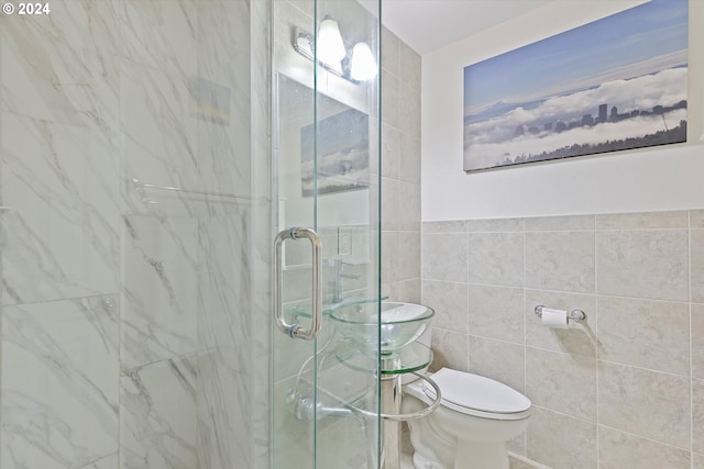 full bathroom featuring toilet, a stall shower, and tile walls