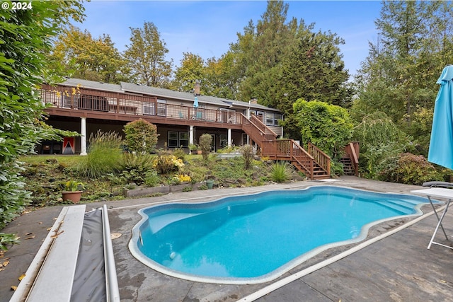 outdoor pool featuring stairway and a wooden deck