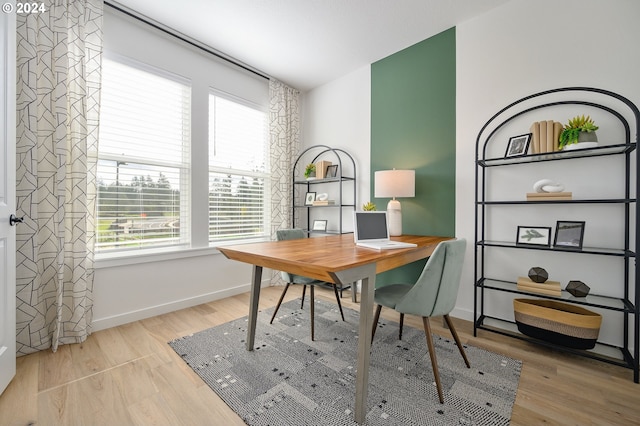 home office with light hardwood / wood-style flooring