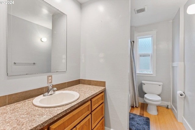 bathroom with hardwood / wood-style floors, vanity, and toilet