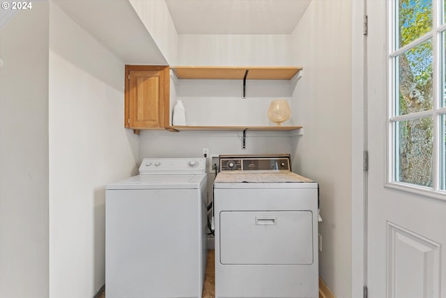 laundry area with cabinets, a wealth of natural light, and washing machine and clothes dryer