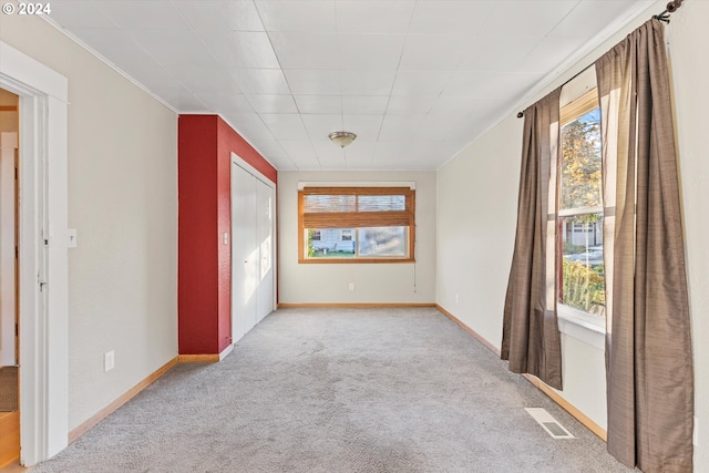 carpeted empty room with crown molding