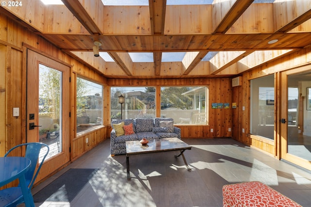 sunroom with beamed ceiling, a skylight, and plenty of natural light