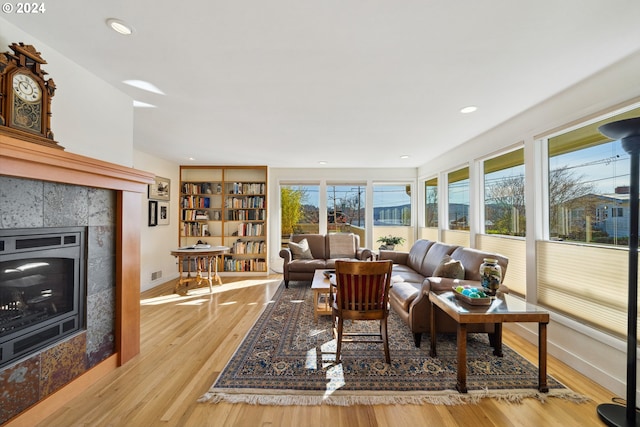 living room with light hardwood / wood-style floors and a tile fireplace