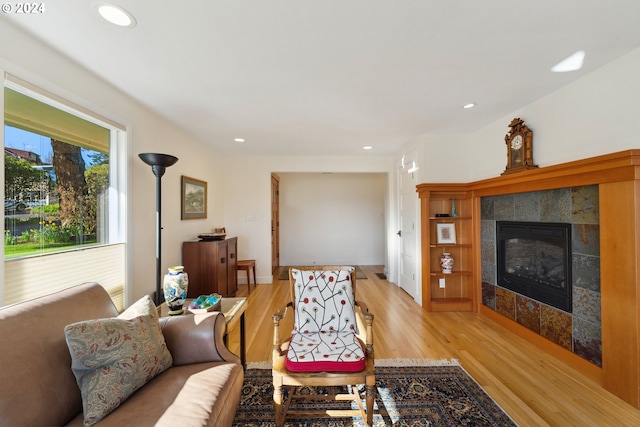 living room featuring light hardwood / wood-style flooring and a tile fireplace