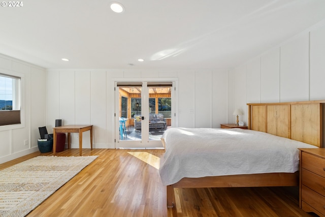 bedroom with hardwood / wood-style floors and access to exterior