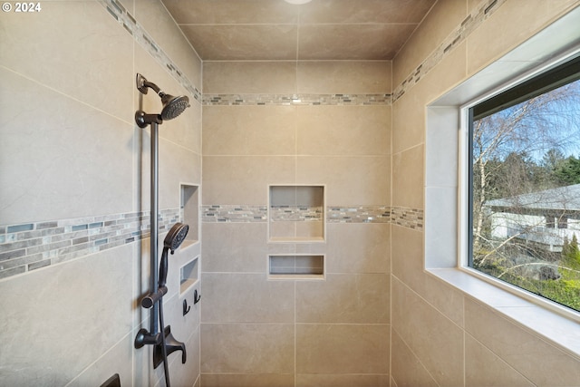 bathroom featuring a healthy amount of sunlight and tiled shower