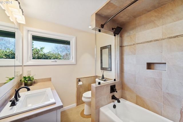 full bathroom featuring a healthy amount of sunlight, vanity, toilet, and tiled shower / bath combo