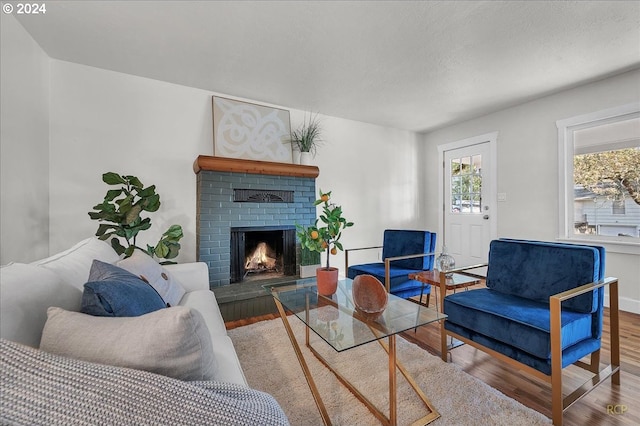 living room with hardwood / wood-style floors and a brick fireplace