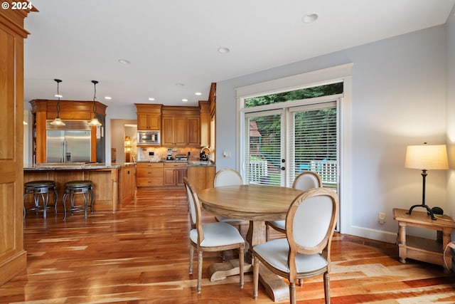 dining space with sink and light hardwood / wood-style floors