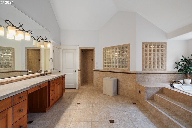 bathroom with lofted ceiling, vanity, tile patterned floors, and tile walls