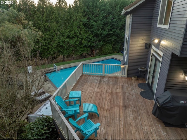 view of pool featuring a wooden deck and area for grilling