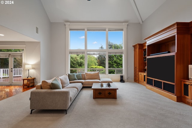 living room featuring french doors, high vaulted ceiling, and light carpet