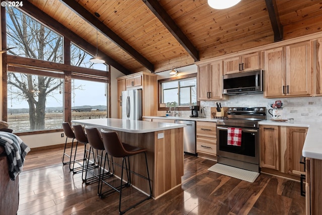 kitchen with sink, a kitchen island, appliances with stainless steel finishes, beam ceiling, and dark hardwood / wood-style flooring