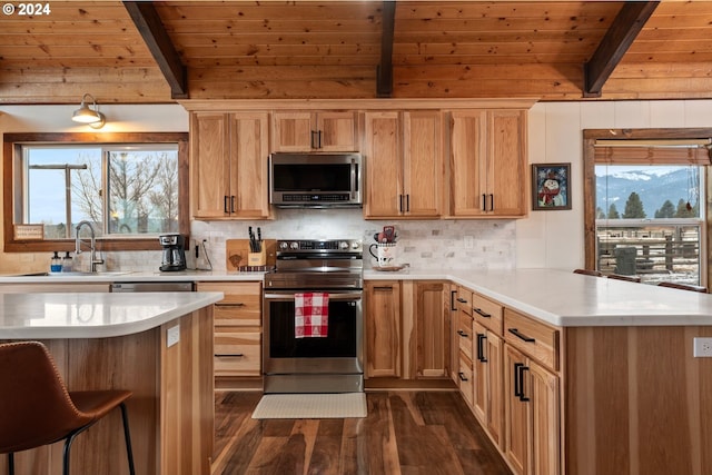 kitchen with dark wood-type flooring, beamed ceiling, kitchen peninsula, stainless steel appliances, and wood ceiling