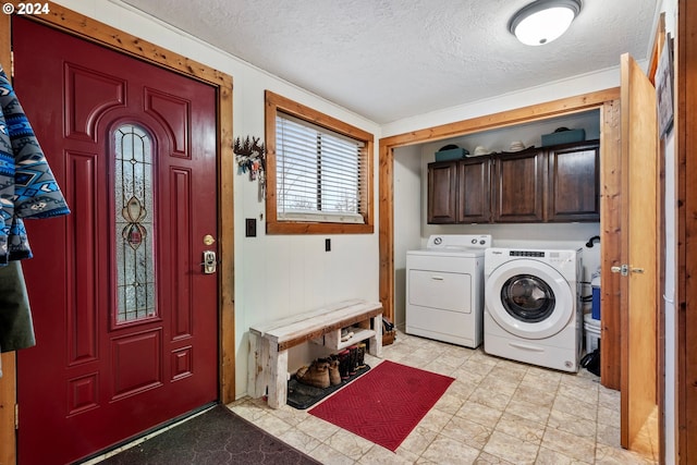 laundry room featuring cabinets, independent washer and dryer, and a textured ceiling