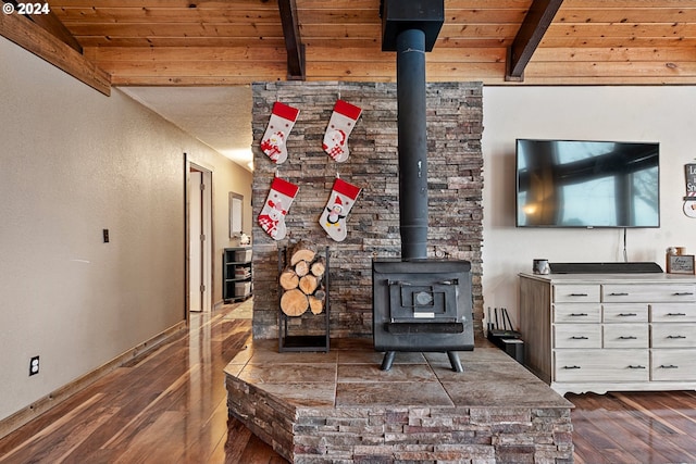 living room featuring dark hardwood / wood-style floors, beam ceiling, a wood stove, and wood ceiling